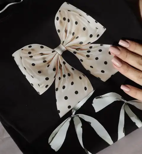 Detalhe de estampa de laço em camiseta preta